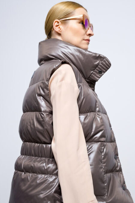 Marron brown vest with high collar and two front pockets. Zipper and stud fastening. Vest with an elastic waistband on the back and natural goose down filling.