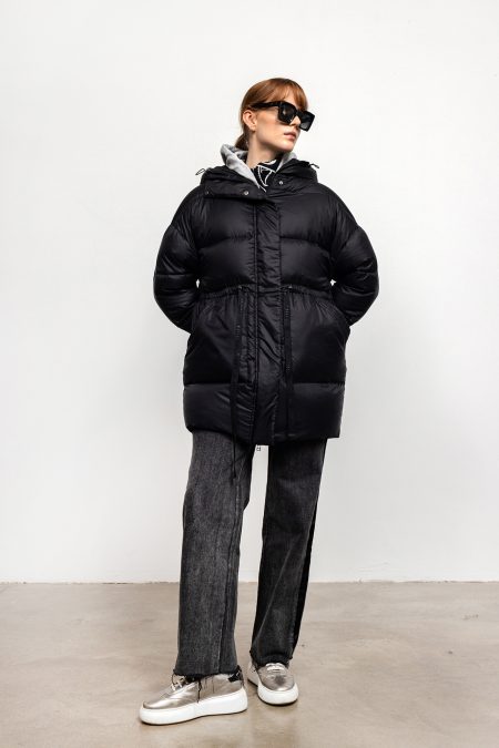 Quilted woman oversized jacket with string at the waist. Zipper and hood, thigh length.