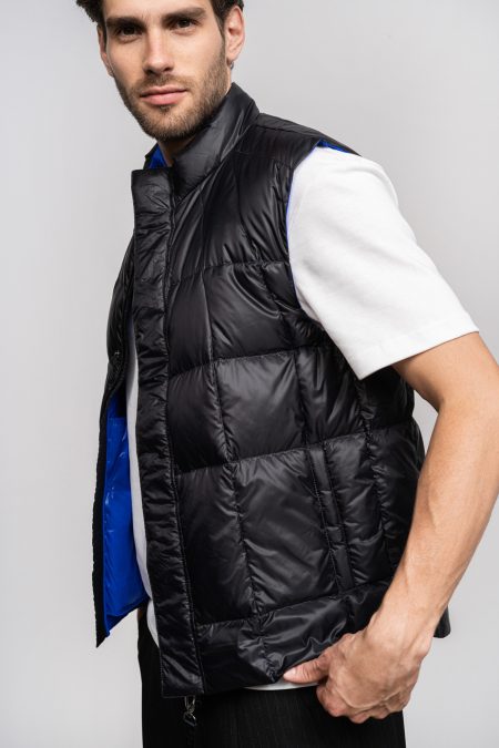 Man light vest with natural down filling. Zipper and front pockets. Compact vest.