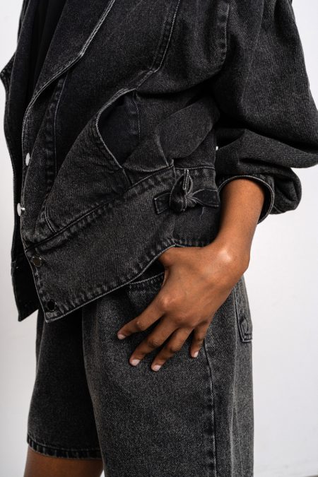 Denim jacket with wide shoulder, soft black denim and buttons on the front.