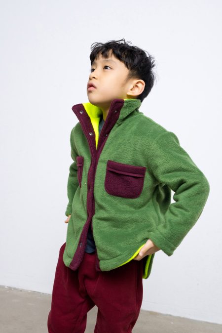 Reversible fleece jacket for kids with two pockets and front pockets, contrasting colours - green and neon. Long sleeve, snap fastening.