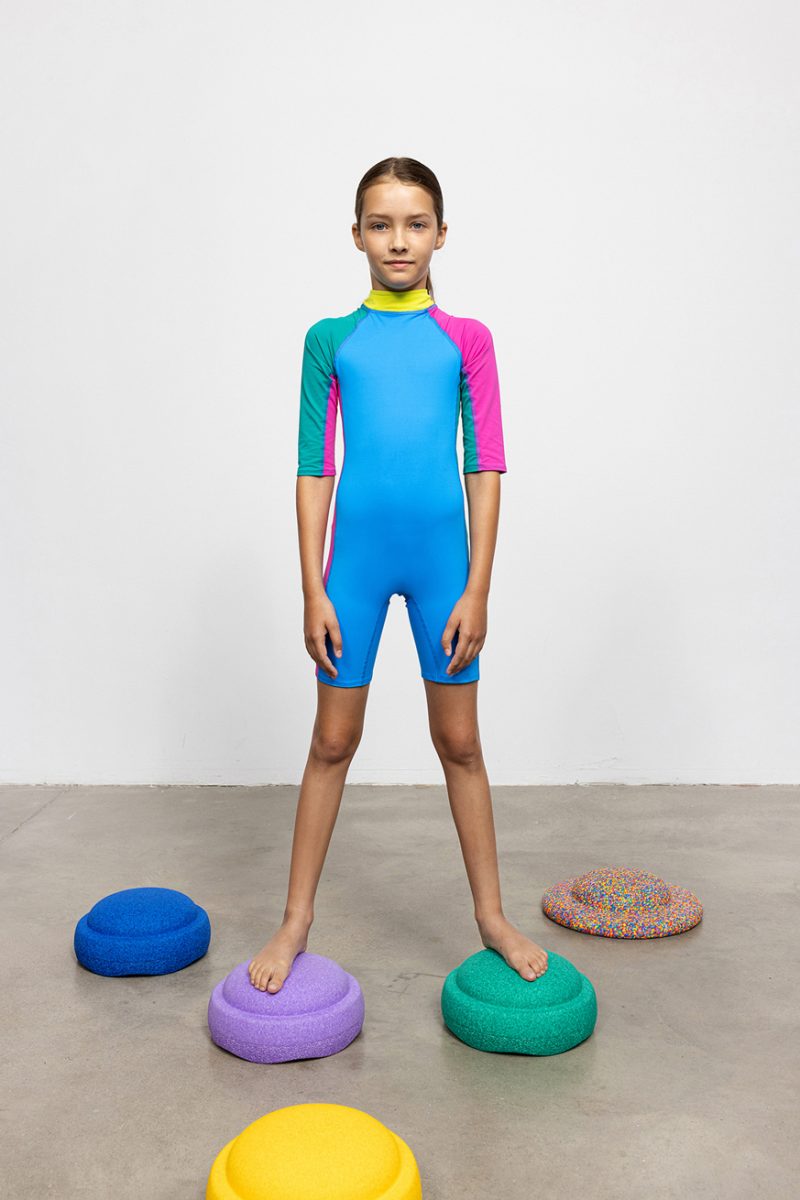 Unisex, colorful (blue, magenta, yellow and green) sun-protection swimsuit for kids with zipper on the back. Easy access with a string, short slleves and knee-lenght. Very comfortable elastic material.